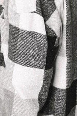 a man wearing a sweater with a checkered pattern