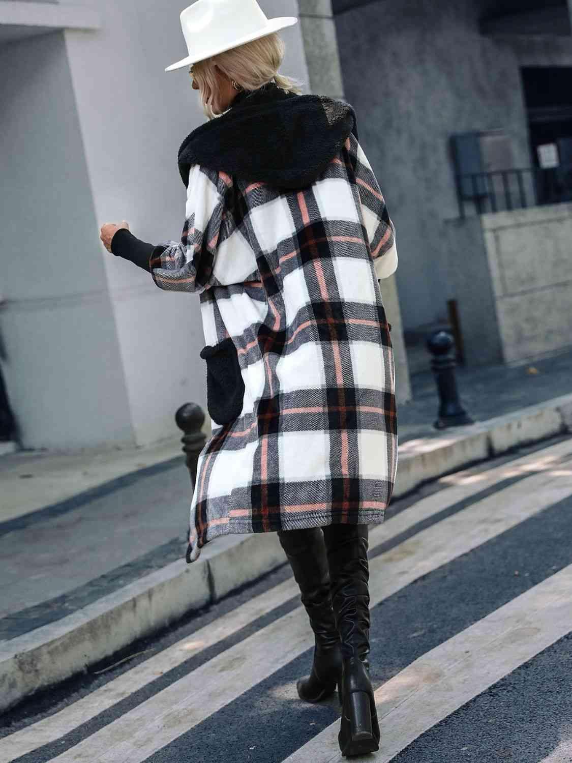 a woman walking down a street wearing a plaid coat