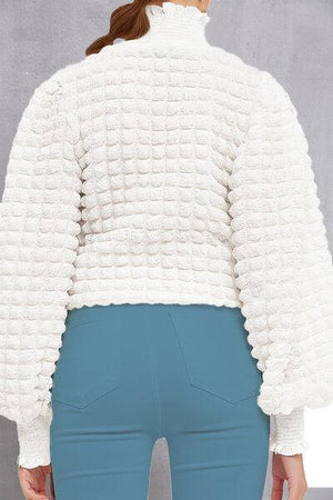 a woman wearing a white jacket and blue pants