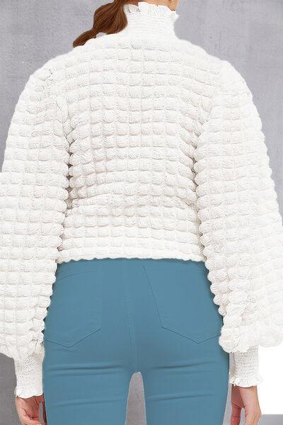 a woman wearing a white jacket and blue pants