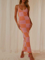 a woman in a pink and orange checkered dress