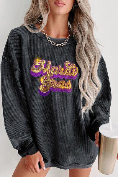 a woman wearing a black sweatshirt with a gold and purple logo on it