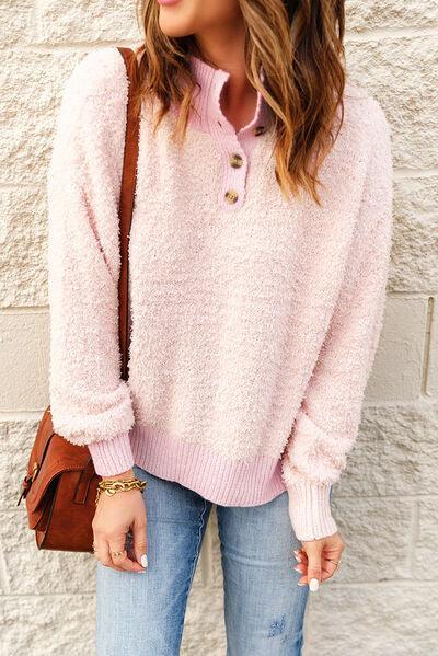 a woman wearing a pink sweater and jeans