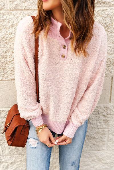 a woman wearing a pink sweater and ripped jeans