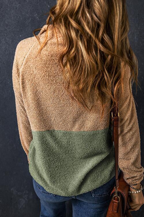 a woman with long hair wearing a sweater and jeans