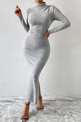 a woman in a grey dress posing for the camera