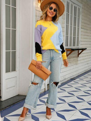 a woman wearing a yellow star sweater and ripped jeans