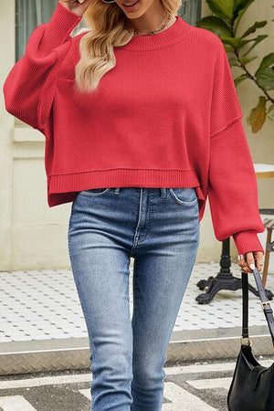 a woman wearing a red sweater and jeans