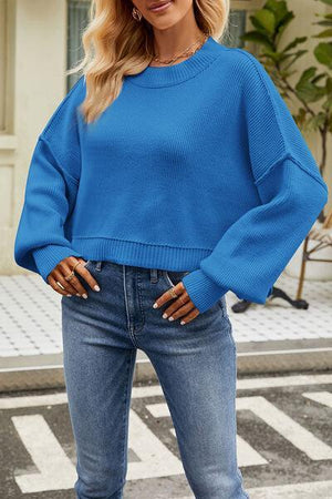 a woman wearing a blue sweater and jeans