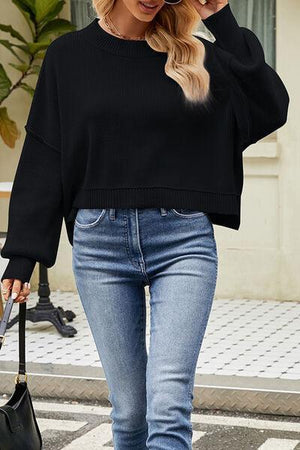 a woman wearing a black sweater and jeans