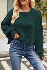 a woman wearing a green sweater and jeans