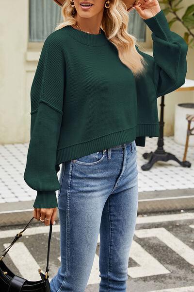 a woman wearing a green sweater and jeans