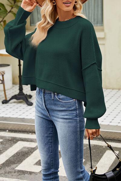 a woman wearing a green sweater and jeans