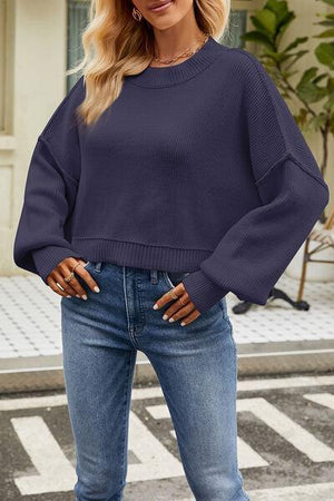 a woman wearing a blue sweater and jeans