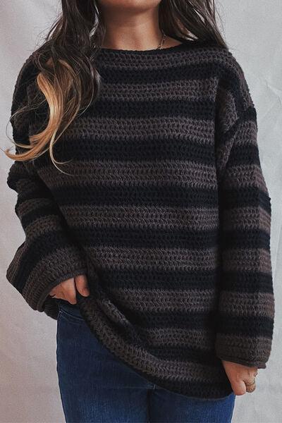 a little girl wearing a black and grey striped sweater