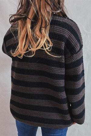 a woman wearing a black and brown striped sweater