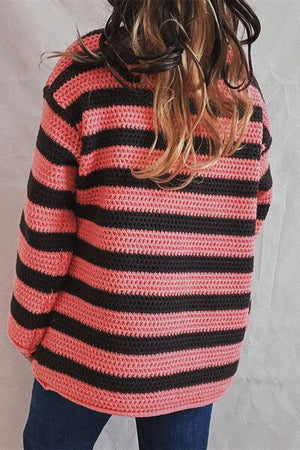 a woman wearing a pink and black striped sweater