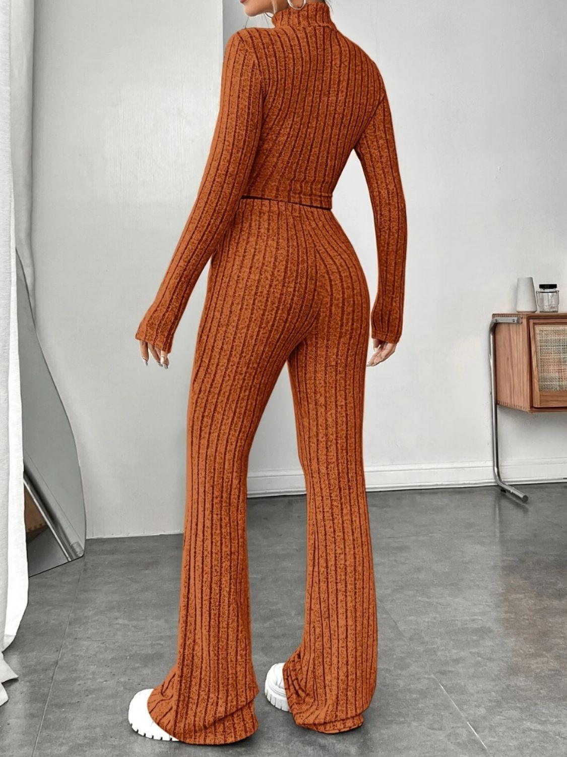 a woman in an orange sweater and wide legged pants