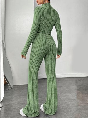 a woman wearing a green knitted jumpsuit and white sneakers