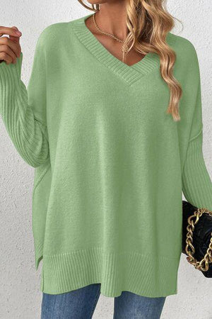 a woman wearing a green sweater and jeans