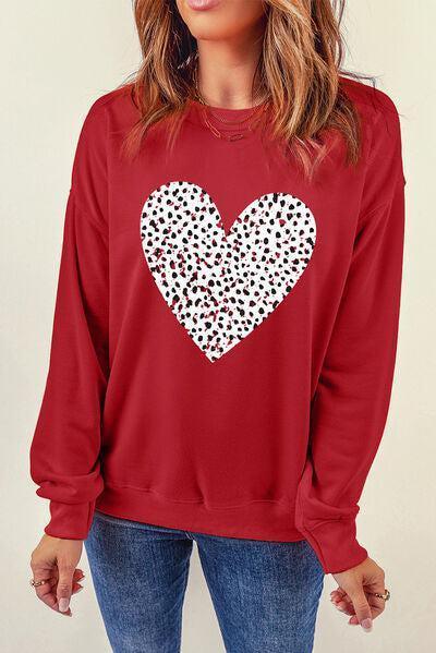 a woman wearing a red sweatshirt with a white heart on it