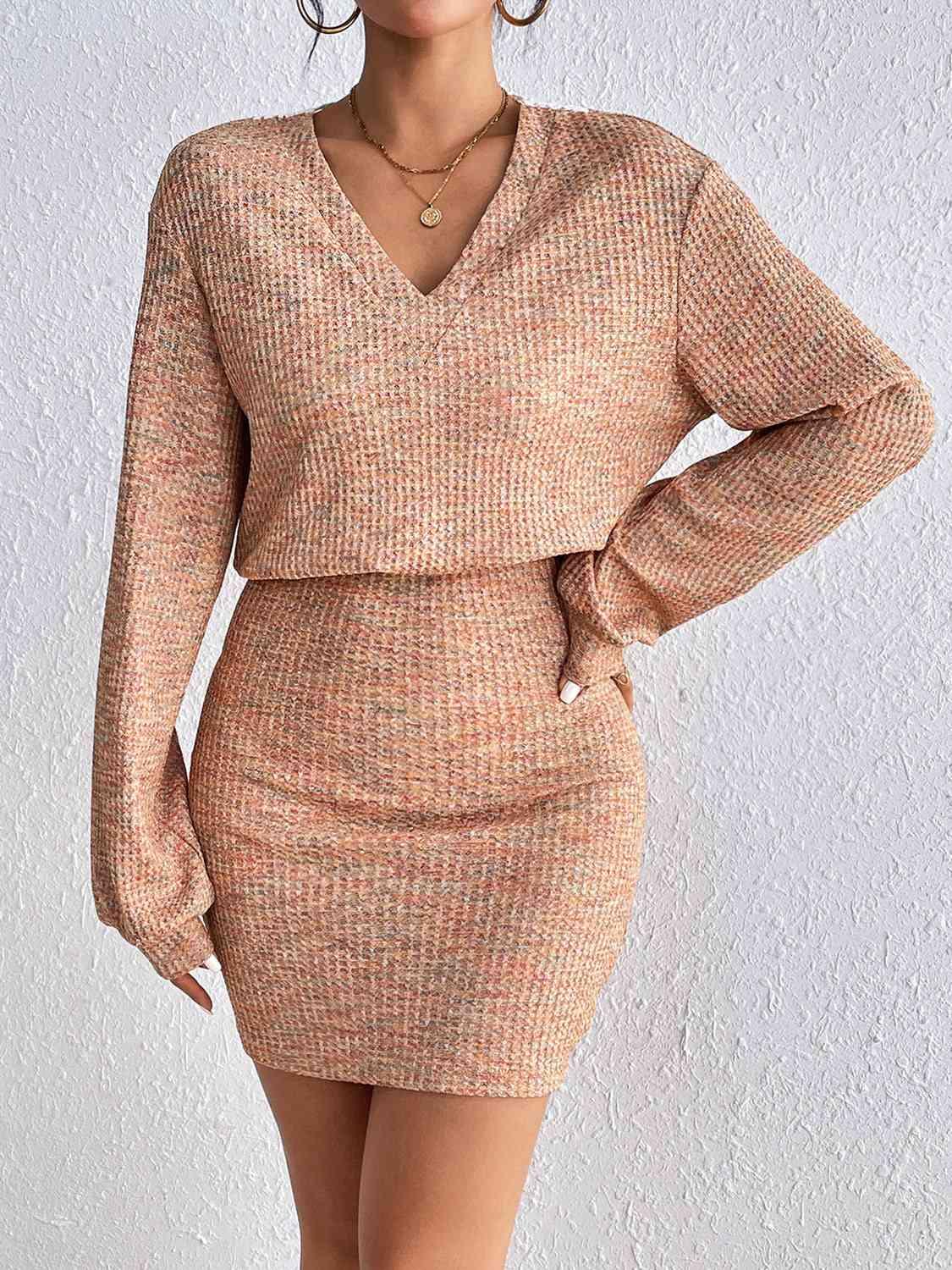 a woman wearing a tan sweater dress