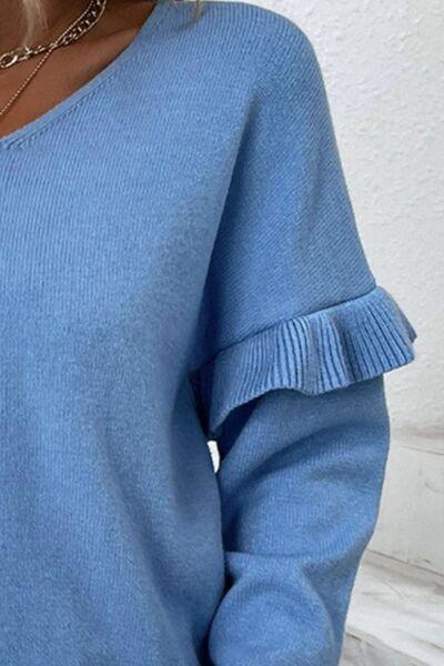 a woman wearing a blue sweater with ruffle sleeves