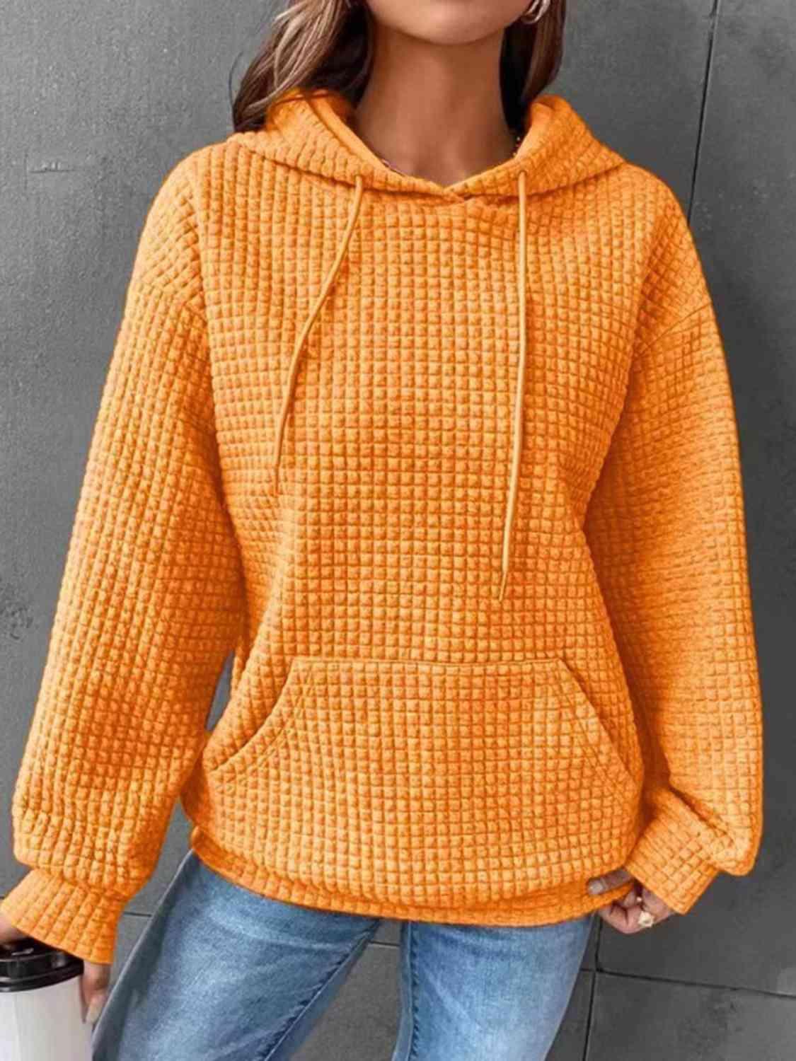 a woman wearing an orange sweater and jeans