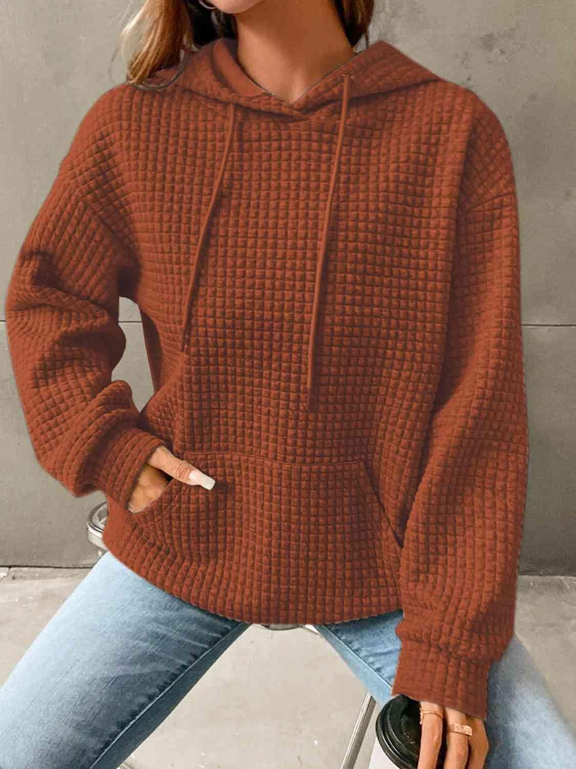 a woman wearing a brown sweater and jeans