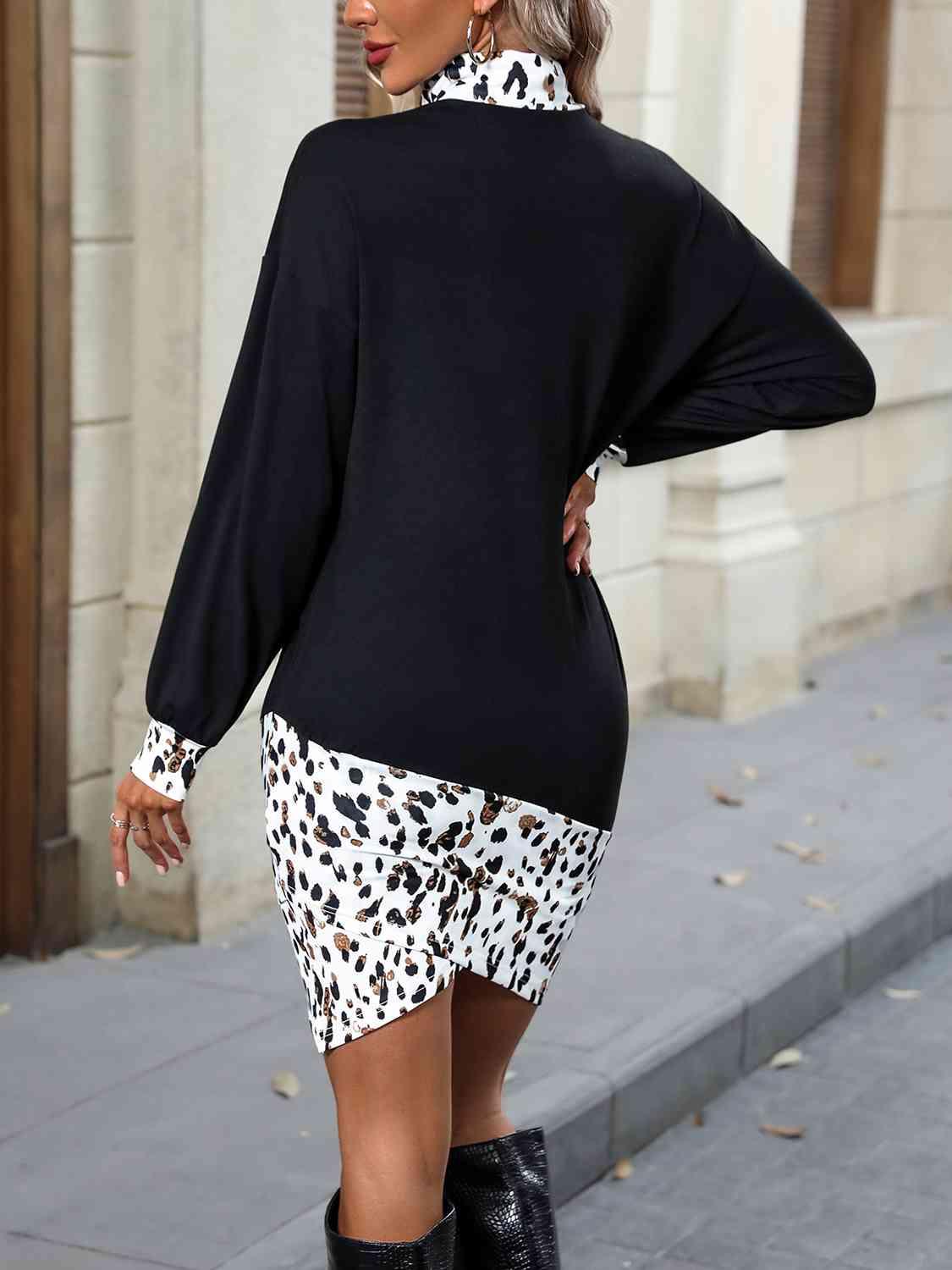 a woman in a black sweater and leopard print skirt