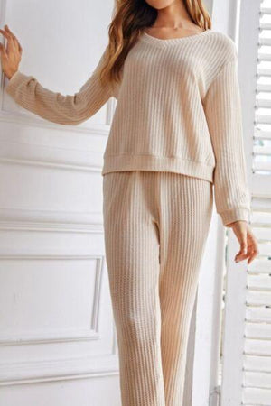 a woman wearing a beige sweater and pants