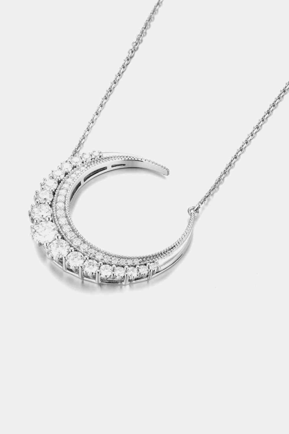 a diamond crescent necklace on a chain
