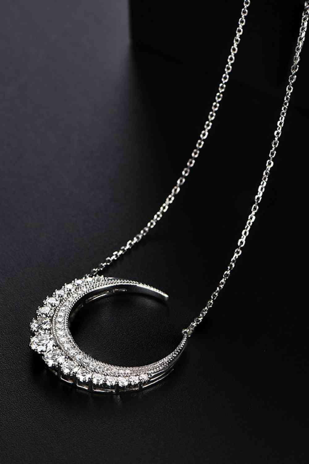 a silver necklace on a black surface