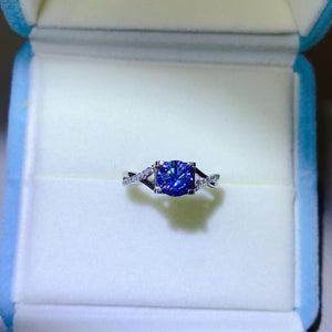 a blue and white diamond ring in a box