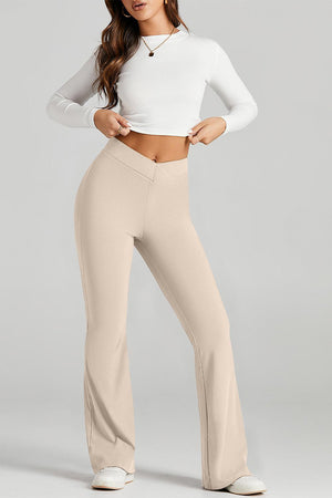 a woman in a white top and beige pants