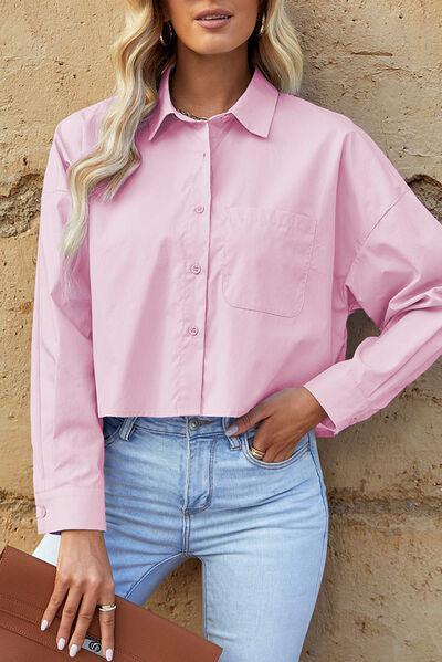 a woman in a pink shirt leaning against a wall