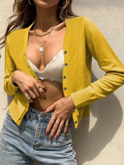 a woman wearing a yellow cardigan and jeans