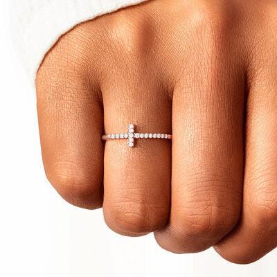 a woman's hand with a cross ring on it