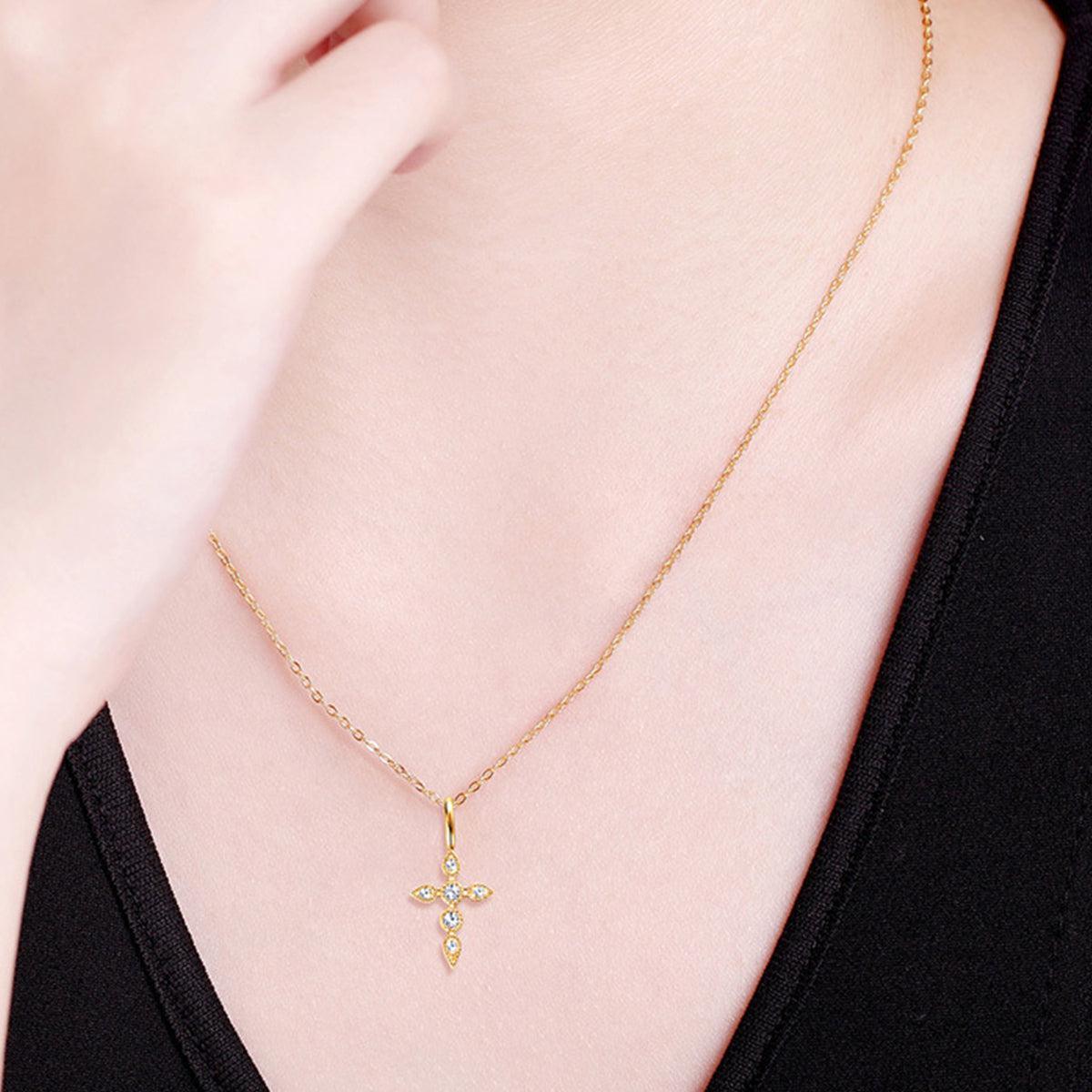 a woman wearing a necklace with a cross on it