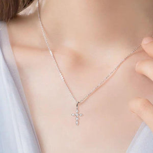 a woman wearing a necklace with a cross on it