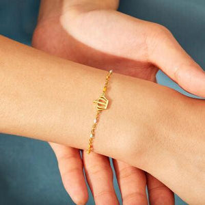 a woman's arm with a gold bracelet on it