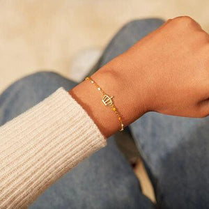 a person wearing a bracelet with a cross on it