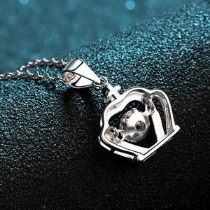 a silver necklace with a heart shaped object on it