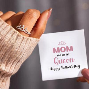 a woman holding a card with a diamond ring on it