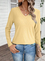 a woman wearing a yellow sweater and jeans