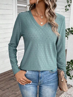 a woman wearing a green sweater and jeans