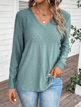 a woman wearing a green sweater and jeans