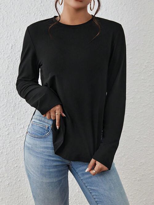 a woman wearing a black top and jeans