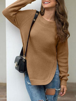 a woman wearing a brown sweater and ripped jeans