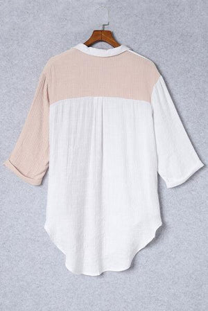 a white and pink top hanging on a wooden hanger